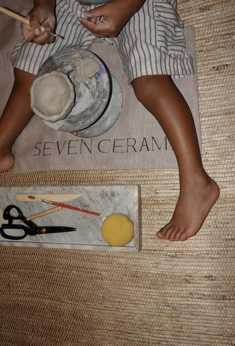 Child hand-building a clay bowl at a Seven Ceramics kids' pottery party