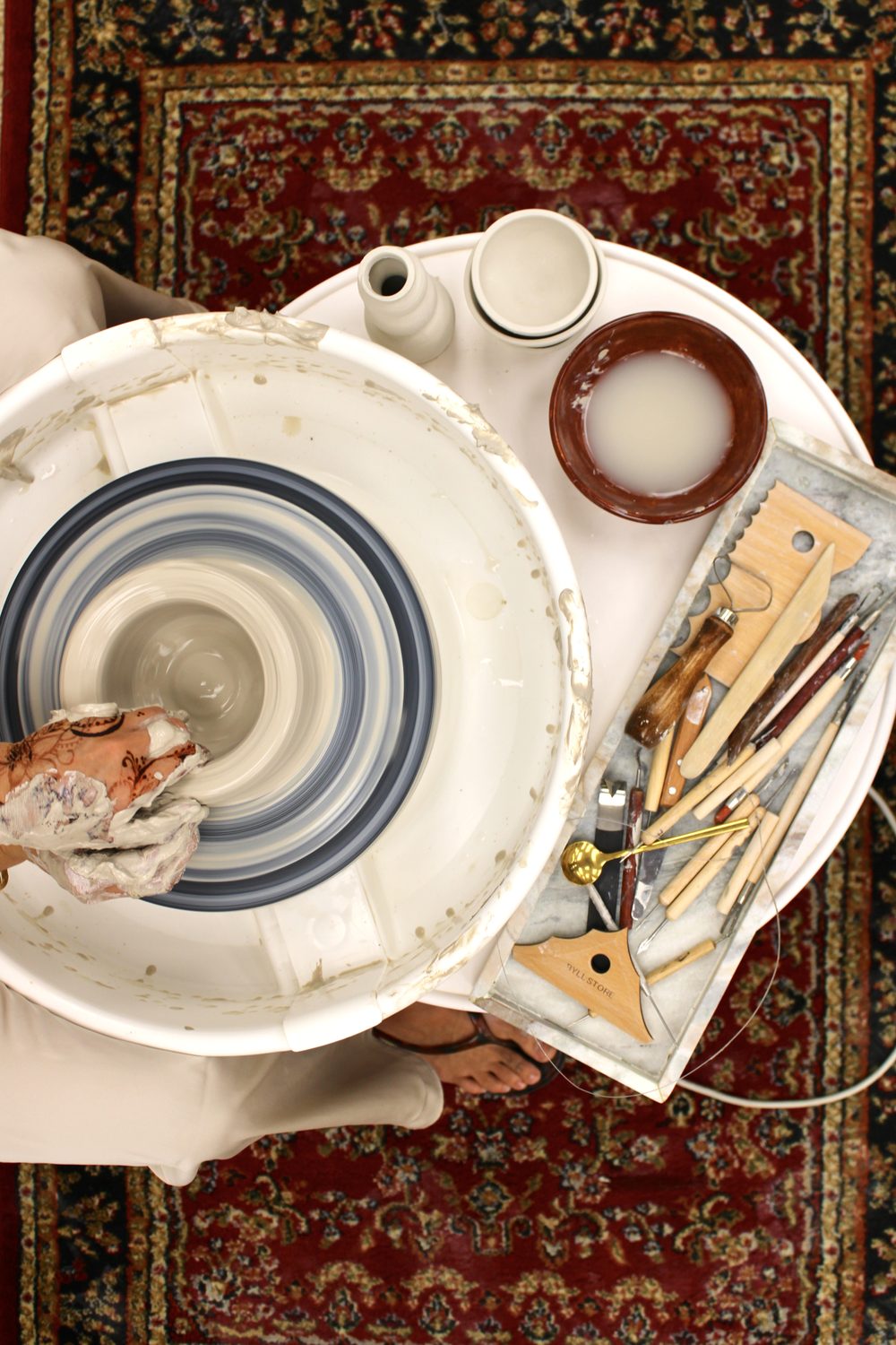 Hand-throwing a bowl on a pottery wheel during a Seven Ceramics private session